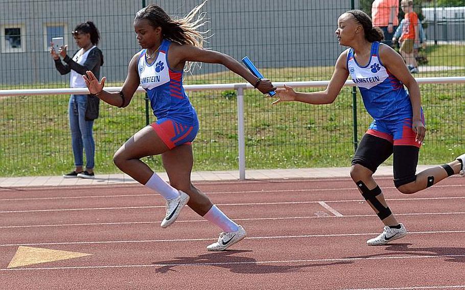 Ramstein's Aryal Allen takes the baton from Jarai Jones on their way to winning the 4x100-meter relay at the DODEA-Europe track and field finals in Kaiserslautern, Saturday, May 25, 2019. Along with teammates Shannon McCray and Casey McCollum they won the race in 50.87 seconds.