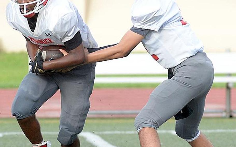 Nile C. Kinnick quarterback Patrick Kelly hands off to teammate Jaden Jones.