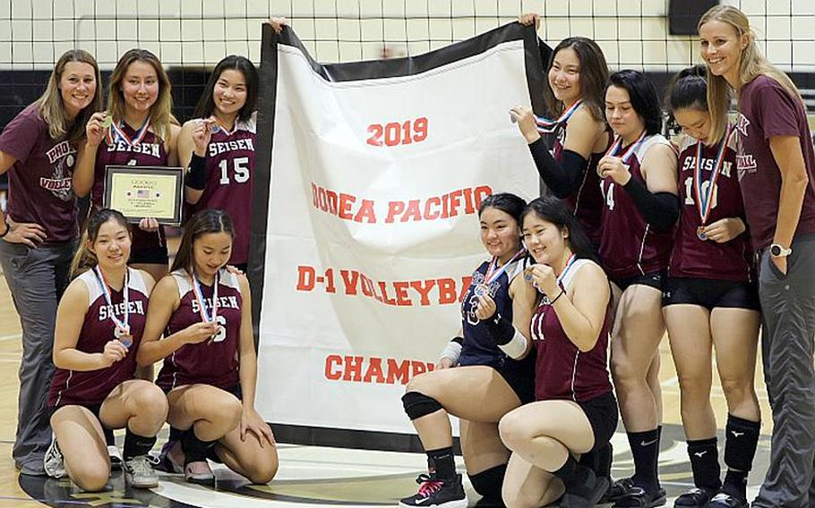 Seisen players and coaches gather round the Far East Division I banner.