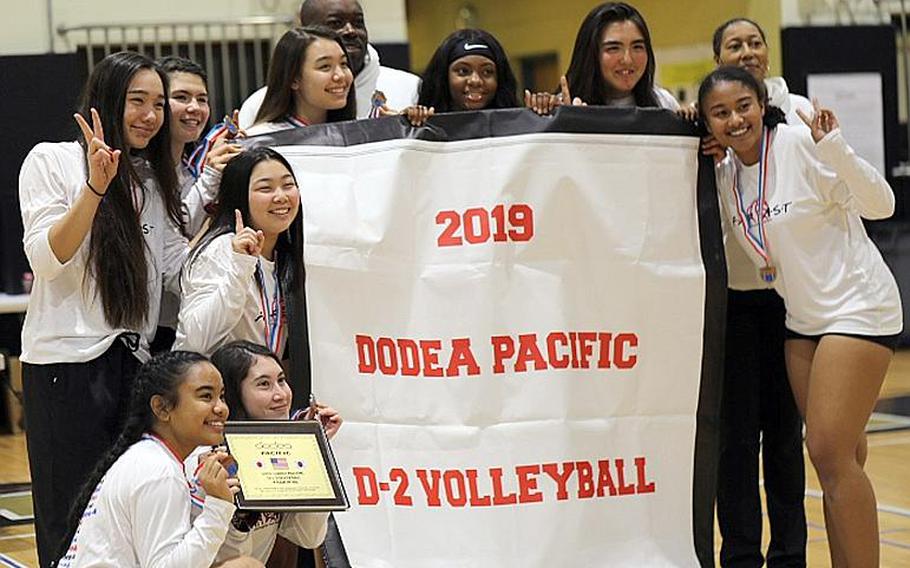 Zama players and coaches gather round the Far East Division II banner.