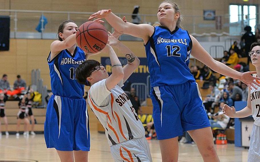 Destiny Tyler of Spangdahlem gets caught between Allison Wenger, left, and Tiana Rodgers as the battle for a rebound in the girls Division III final at the DODEA-Europe basketball championships in Wiesbaden, Germany, Saturday, Feb. 22, 2020. Spangdahlem won 37-21.