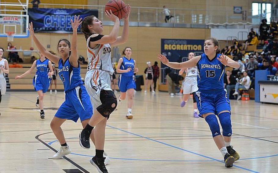 Bridget Donovan of Spangdahlem takes a shot as June Smith of Hohenfels comes in to defend in the girls Division III final at the DODEA-Europe basketball championships in Wiesbaden, Germany, Saturday, Feb. 22, 2020. At left is Kate Farrell. Spangdahlem won 37-21.