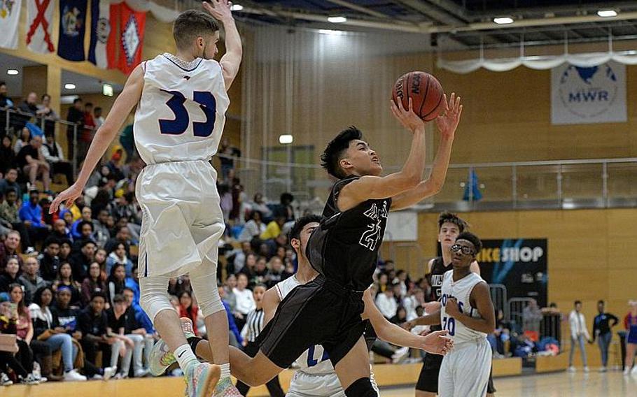 Cameron Gaetos of Vilseck avoids Luis Figueroa to go in for a basket in the boys Division I final at the DODEA-Europe basketball championships in Wiesbaden, Germany, Saturday, Feb. 22, 2020. Vilseck took the title with a 56-42 win.