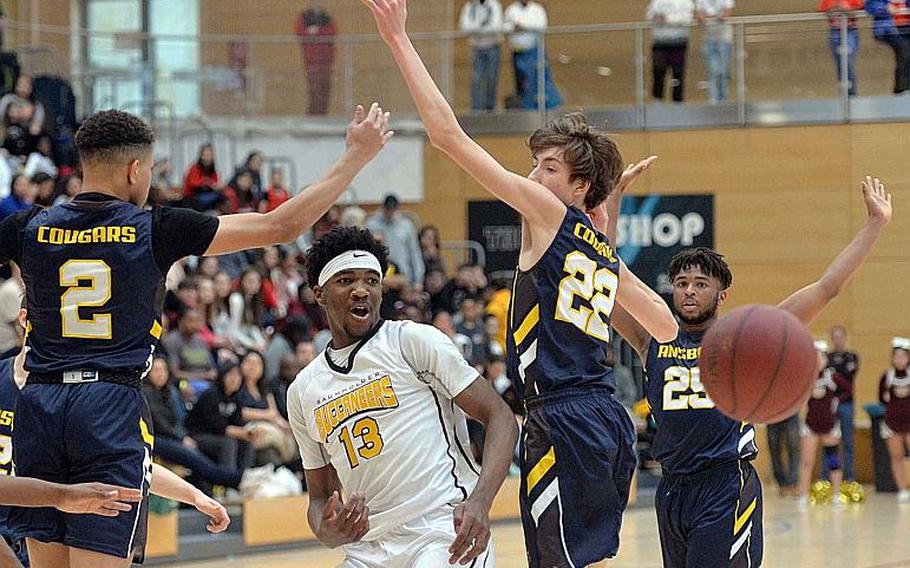 Chandler Pigge of Baumholder passes off to a teammate between Brendan Henderson and Alexander Adams of Ansbach in the boys Division III championship game at the DODEA-Europe basketball finals in Wiesbaden, Germany, Saturday, Feb. 22, 2020. Baumholder won 50-43.