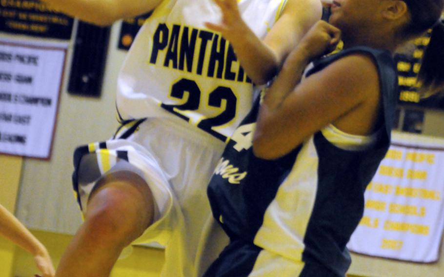 Kadena guard Maria Vaughan (22) drives for a shot against Kubasaki defender J.J. Wilson during Wednesday's game at Kadena Air Base, Okinawa. Kadena won 77-51, while Kubasaki's boys remained unbeaten at 14-0 by beating Kadena 73-66; the Panthers girls and Dragons boys each lead their respective OAC season series 2-0.