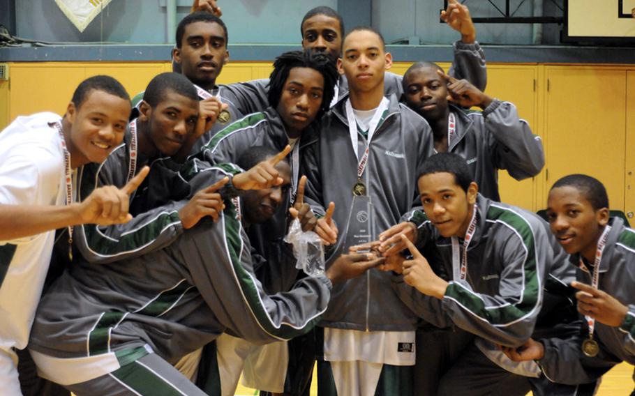 Kubasaki Dragons boys basketball players gather round the championship hardware after Sunday's championship game in the 5th New Year Classic high school basketball tournament. Kubasaki won the tournament for the second time, beating Yokota 58-39 in the title game.