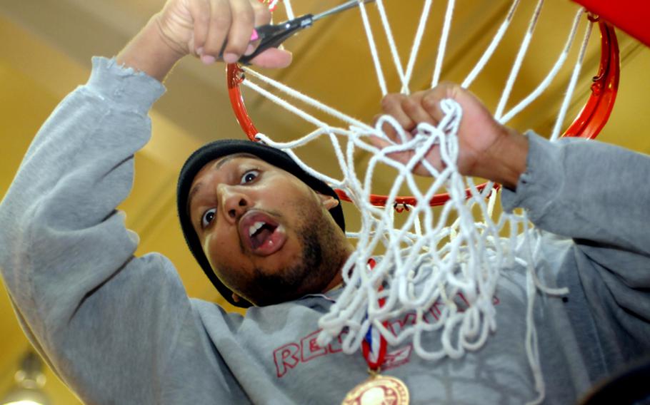 Kevin Tasker of Team of Champions cuts down the net cords after the men's championship games.