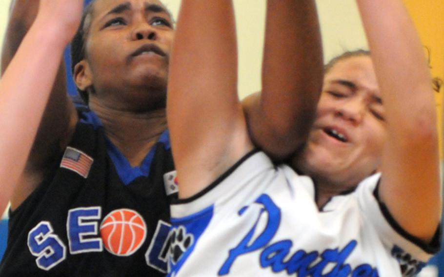 Ayanna Thomas of Yokota gets an elbow to the face from Seoul American's Diamond Person on a rebound during Friday's semifinal game in the Far East High School Girls Division I Basketball Tournament at Charles King Fitness & Sports Center, Naval Base Guam. Seoul American reached its sixth final in seven years by beating Yokota, 65-45.