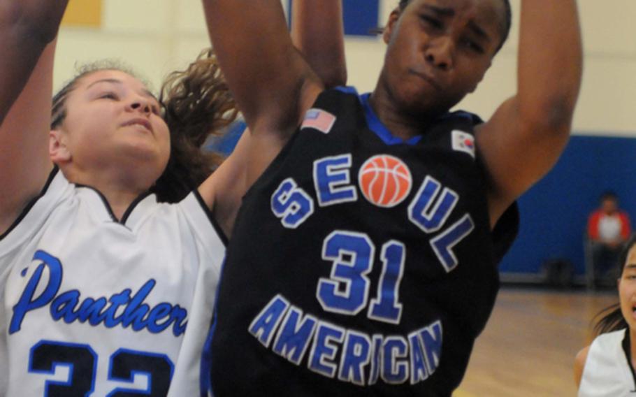 Seoul American's Diamond Person snags a rebound away from Yokota's Sydney Glover during Friday's semifinal game in the Far East High School Girls Division I Basketball Tournament at Charles King Fitness & Sports Center, Naval Base Guam. Seoul American reached its sixth final in seven years by beating Yokota, 65-45.