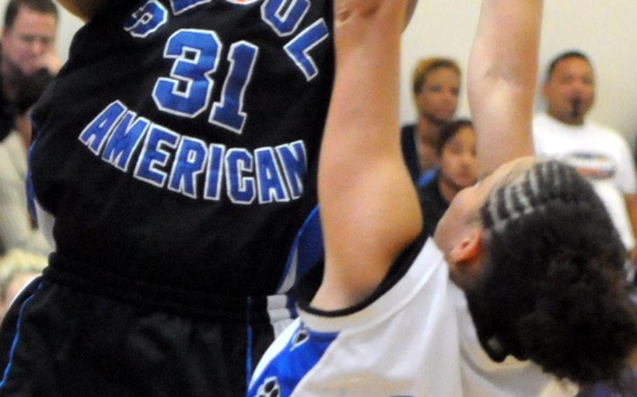 Seoul American's Diamond Person shoots over Yokota's Ayanna Thomas during Friday's semifinal game in the Far East High School Girls Division I Basketball Tournament at Charles King Fitness & Sports Center, Naval Base Guam. Seoul American reached its sixth final in seven years by beating Yokota, 65-45.