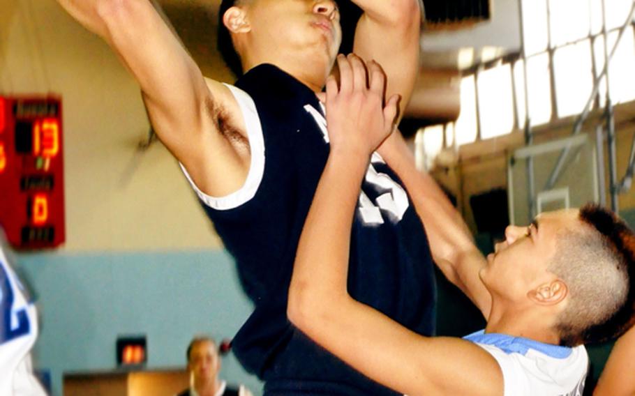 Morrison Academy's Calvin Lee puts up a shot over St. Paul Christian's Mark Canovas during Friday's championship game in the Far East High School Boys Division II Basketball Tournament at Kelly Fitness & Sports Center, Camp Walker, South Korea. Morrison captured its third straight title and fifth overall by beating St. Paul, 63-32.