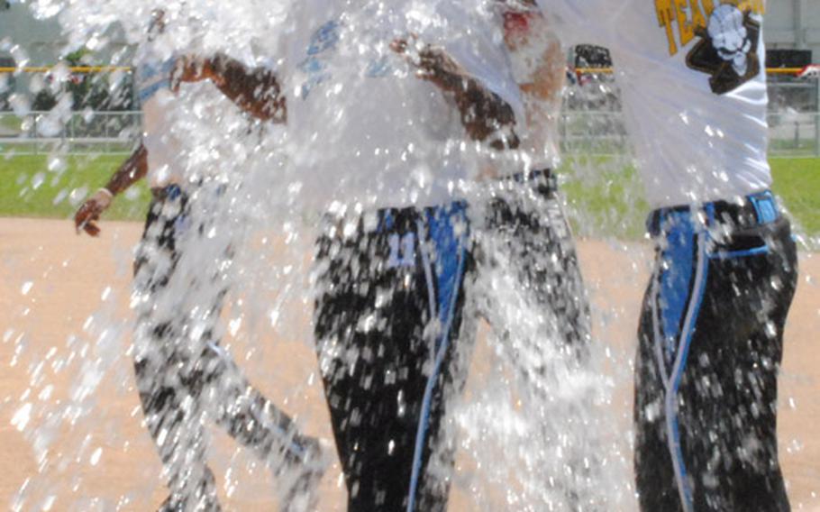 Camp Casey/Area I team captain Tony Hilliard gets the water-bucket treatment after Monday's men's championship games in the 2011 Firecracker Shootout Pacificwide interservice softball tournament at Field 1, Gunners Fitness & Sports Complex, Camp Foster, Okinawa. Casey lost the first championship game in the double-elimination finals to American Legion 15-7, then dethroned defending champion Legion 9-2 in the second and deciding final game.