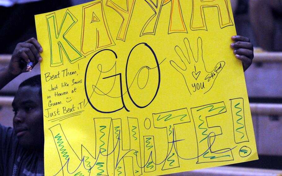 Yokota High School junior Phillip Burnett holds up a sign in support of Panthers senior setter Kathryn White during Tuesday's Kanto Plain Association of Secondary Schools girls volleyball match at Yokota Air Base, Japan. American School In Japan's Mustangs rallied from a one-set deficit to win 19-25, 25-20, 25-20, 25-10.