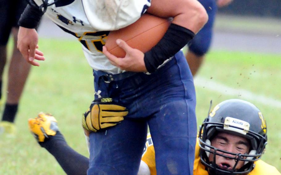 Guam High running back Damian Dimmick is brought down by Kadena defender Chris McQuillen during Monday's Far East Division I football play-in game at Kadena Air Base, Okinawa. Kadena shut out Guam High 6-0.