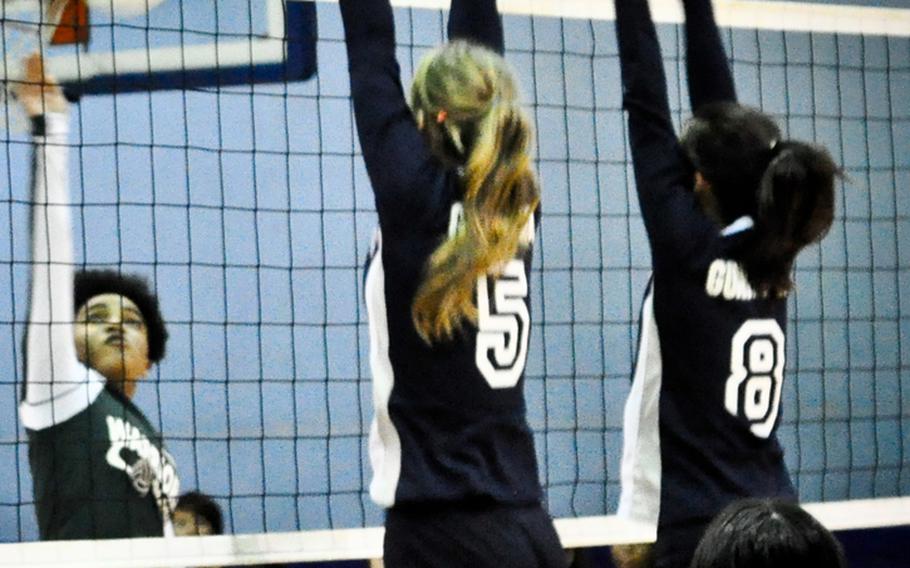 Daegu High's Rachel Wyche bangs the ball over the net through a double block by Yongsan International-Seoul's Sarah Waldrop and SuYoung Yang during the pool-play match in the 2011 Far East High School Girls Division II (small schools) Volleyball Tournament at Kelly Fitness & Sports Center, Camp Walker, South Korea on Nov. 8, 2011. Daegu survived the Guardians in four sets and earned one of two top seeds entering the double-elimination playoffs.