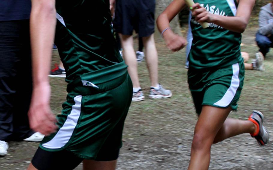 Alle Robles of Kubasaki, right, passes the baton to teammate Erik Armes during the 6.2-mile team-relay portion of the 2011 Far East High School Cross-Country Meet at Tama Hills Recreation Center, Tokyo on Nov. 8, 2011. Armes and Robles, the Okinawa Activities Council island champions, crossed in 34 minutes, 24.9 seconds and Kubasaki won the team relay and overall team titles for the first time in school history.