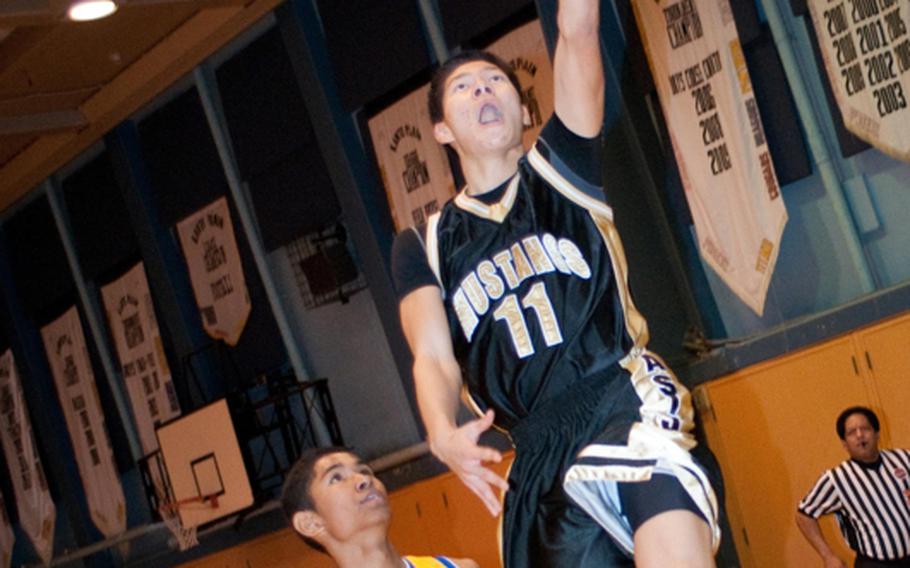 American School In Japan Mustangs' guard Ken Yajima (11) shoots past defender Mikey Henagan (32) of the Yokota Panthers during the championship game Dec. 18, 2011, in the American School In Japan Holiday Classic boys basketball tournament at Mustang Valley Fitness & Sports Center, ASIJ Chofu Campus, Tokyo. ASIJ beat Yokota 69-47.