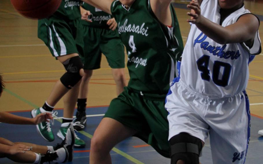 Kubasaki Dragons' Marylin Rodriguez (4) and Yokota Panthers' Danielle Davis (40) battle for a loose ball during the pool-play game Dec. 19, 2011, in the Yokota High School Christmas Classic girls basketball tournament at Capps Gym, Yokota High School, Yokota Air Base, Japan. Yokota won 73-22.