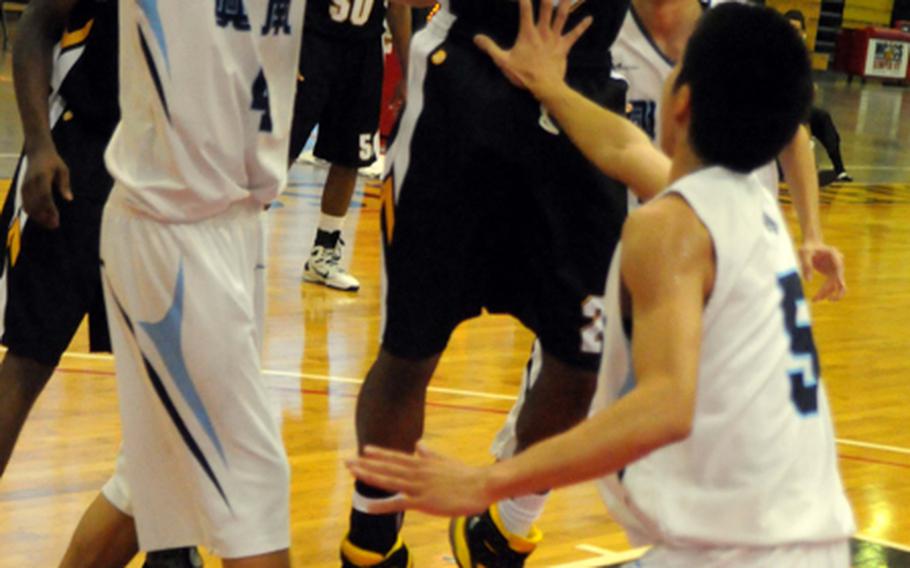 Kadena Panthers guard Andre Chilton puts up a shot over Konan Shisa defenders Taishi China (4) and Muneyuki Machida (5) during the boys championship game in the 6th Okinawa-American Basketball Shootout on Jan. 22, 2012, at Camp Foster, Okinawa. Kadena edged Konan 73-67, ending a two-year losing streak to the Shisa in the Shootout championship.