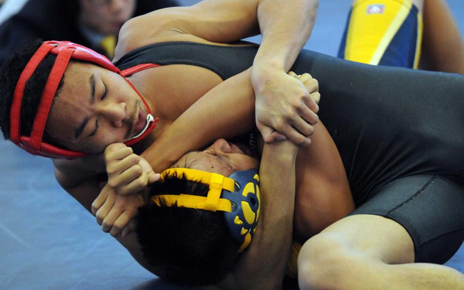 Marvin Newbins of Nile C. Kinnick catches Guam High's Gabriel Bongat in a head-in-arm hold during the 129-pound pool-play bout Feb. 13, 2012, in the 35th Far East High School Wrestling Tournament at  Yokosuka Naval Base, Japan. Newbins pinned Bongat in 2 minutes, 30 seconds.