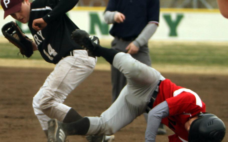 E.J. King's Regan Young goes airborne after colliding with Matthew C. Perry infielder Eric Kox during Thursday's DODDS Japan baseball tournament game at Naval Air Facility Atsugi. Young's Cobras beat the Samurai 8-4.