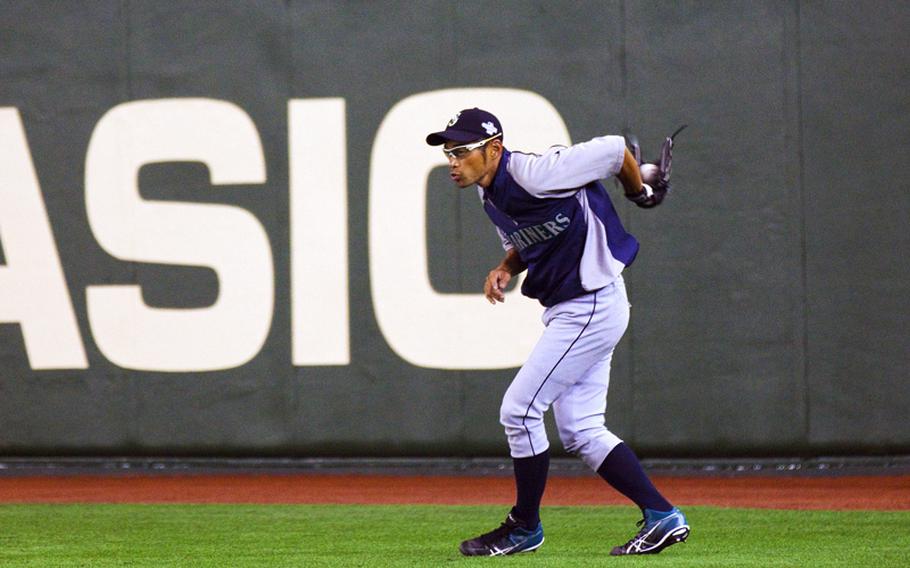 Seattle Mariners right fielder Ichiro Suzuki catches a fly ball behind his back Saturday during practice at the Tokyo Dome in Tokyo.