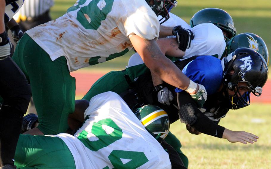 Kadena Dragons quarterback Matthew Fuller is brought down by Camp Hansen Wolfpack defenders Kentrell McCoy (58), Derrick Williams (94), Kyle Haupt and Joseph Jackson during the South Division quarterfinal in the U.S. Forces Japan-American Football League playoffs on July 7, 2012, at Kadena Air Base, Okinawa. The Wolfpack routed the Dragons 30-0.
