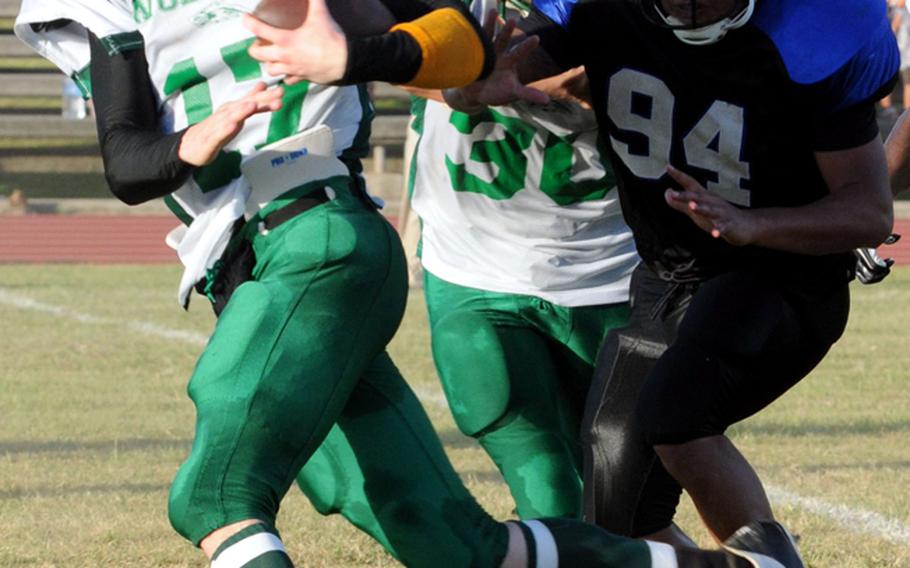 Camp Hansen Wolfpack quarterback Daren Monk (17) evades Kadena Dragons defender Oscar Campos (94) during the South Division quarterfinal in the U.S. Forces Japan-American Football League playoffs on July 7, 2012.