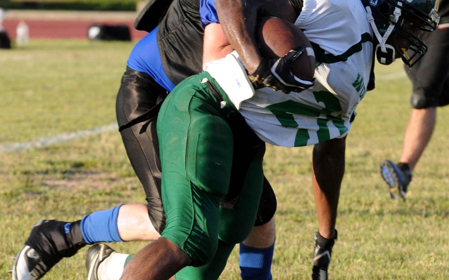 Kadena Dragons linebacker Randall Machuca wraps up Camp Hansen Wolfpack running back Hasani Ferraro (25) during the South Division quarterfinal in the U.S. Forces Japan-American Football League playoffs July 7, 2012.
