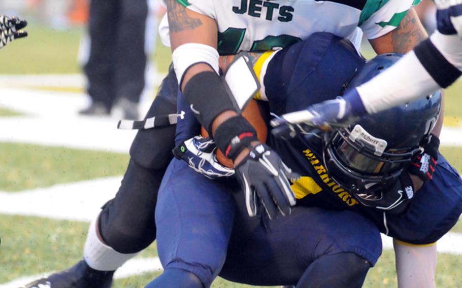 Yokota Warriors running back Chris Ekstrom (1) gets hauled down by Misawa Jets defender Kasaun Thomas during the U.S. Forces Japan-American Football League North Division championship game July 21, 2012, at Yokota Air Base, Japan. The Warriors routed the Jets 39-6 to reach their third Torii Bowl title-game berth in four years; they'll play at defending champion Foster on Aug. 4.