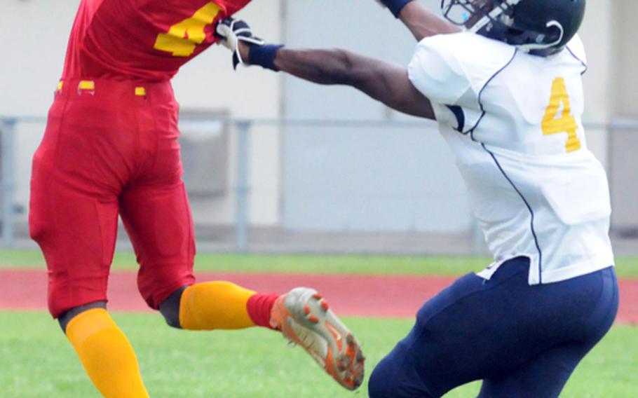 Camp Foster Bulldogs receiver Tony Moses watches the ball go through his hands as Yokota Air Base Warriors' Shane Polk defends during the U.S. Forces Japan-American Football League Torii Bowl title game Aug. 4, 2012, at Kubasaki High School, Okinawa. Yokota won 20-12 for its second Torii Bowl title in three years.