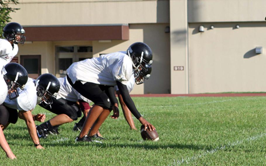 Coach Steven Merrell works with the first-string offense Aug. 14, 2012, during Zama American High School's football practice.