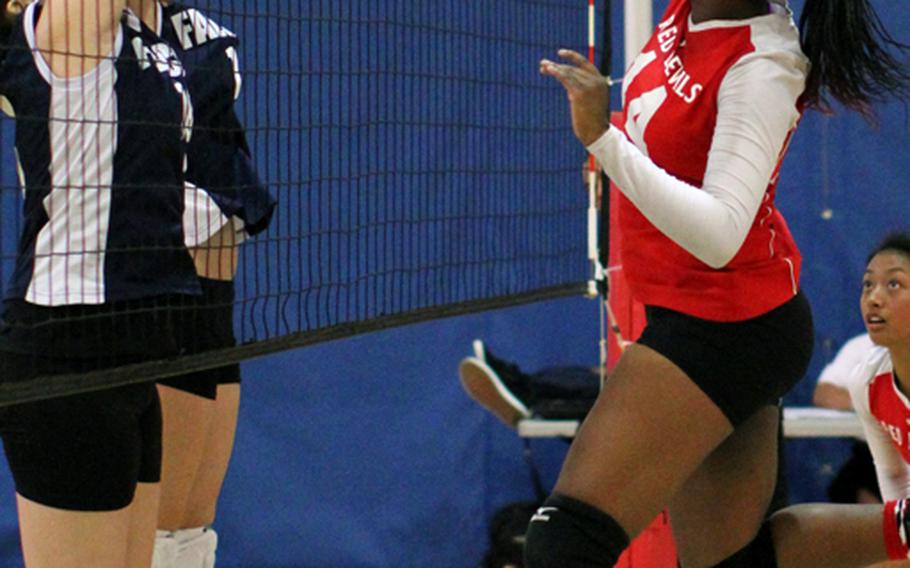 Middle blocker Audri Salter of Nile C. Kinnick Red Devils pounds the ball through Seoul American middle blockers during Monday's pool-play match in the Far East High School Girls Division I Volleyball Tournament at Charles King Fitness & Sports Center, Naval Base, Guam. Kinnick won in straight sets 25-9, 25-21.