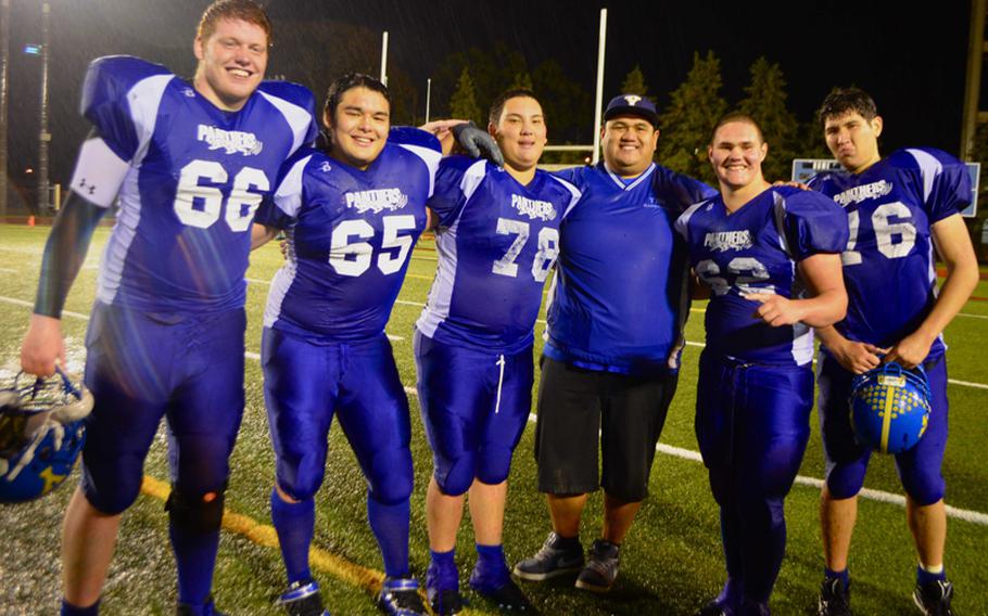 From left, Yokota Panthers right tackle Jesse Hogan, right guard Dylan Kessler, center Victor Madaris, line coach Ernie Carrasco, left guard Jake Jackson and left tackle Max Lester, all of whom have been together since they were freshmen, celebrate the Panthers' second straight Far East Division I football title after Saturday's 55-8 romp over Kubasaki.