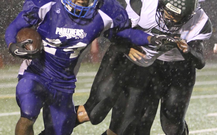 Yokota running back Raymond Butler outruns a pair of Kubasaki defenders during Saturday's Far East High School Division I football championship game at Yokota Air Base, Japan. Yokota won 55-8 for its second straight D-I title.