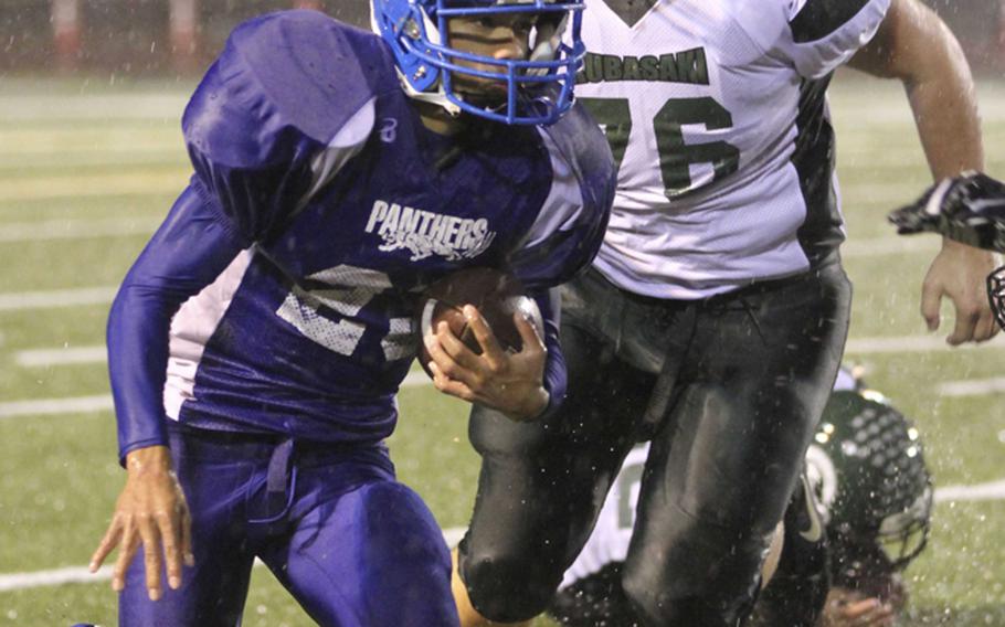 Yokota running back Morgan Breazell dashes away from Kubasaki defender Luke Pirrota during Saturday's Far East High School Division I football championship game at Yokota Air Base, Japan. Yokota won 55-8 for its second straight D-I title.
