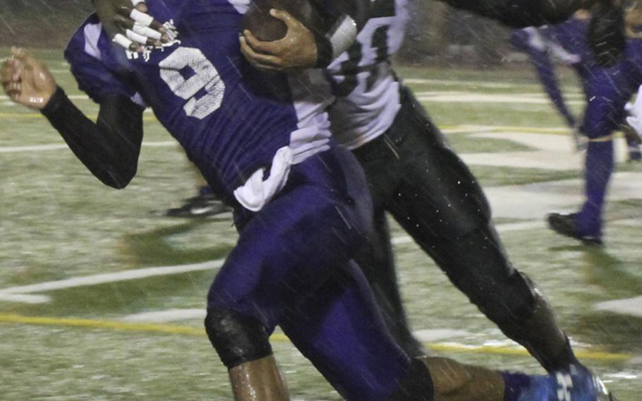 Yokota quarterback Stanley Speed tries to avoid the tackle of Kubasaki  defender Kareem Key during Saturday's Far East High School Division I football championship game at Yokota Air Base, Japan. Yokota won 55-8 for its second straight D-I title.