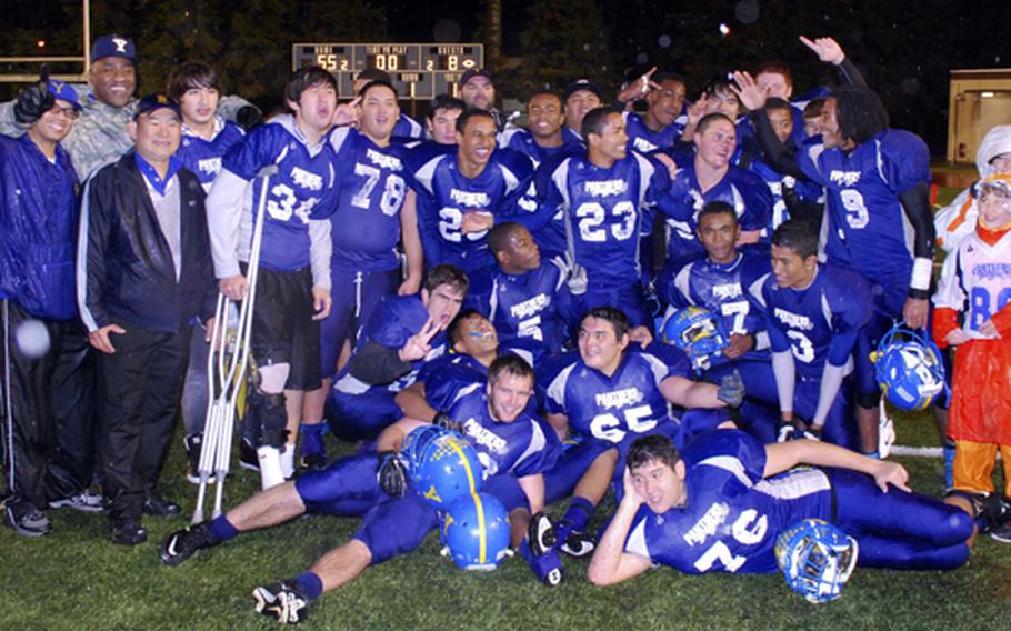 Yokota Panthers coaches, players and student managers celebrate the team's second straight Far East Division I football championship. Yokota beat Kubasaki 55-8 on Saturday.