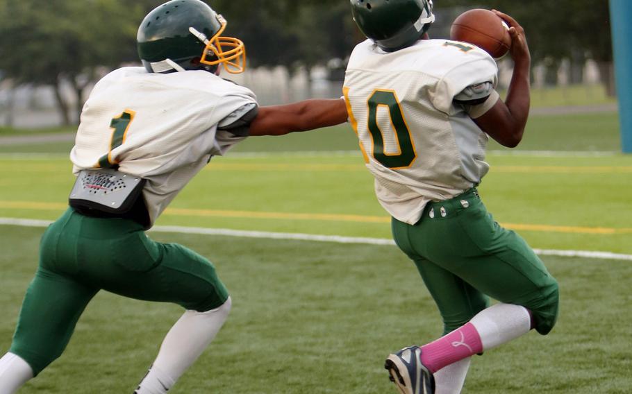 Khaleem Shabazz makes an over-the-shoulder catch as Tyrone Bacalso defends during Monday's Robert D. Edgren Eagles football practice at Misawa Air Base, Japan.