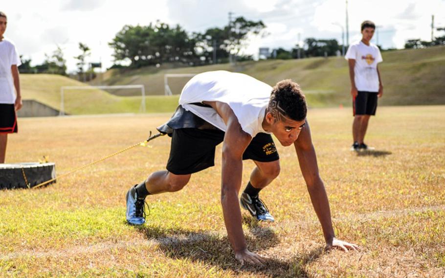 Kadena senior tight end Damien Reese gets set to do a tire-pull drill during a recent practice at Kadena High School. Reese and fellow senior James Alexander are the leaders of a line long on numbers but short on experience.