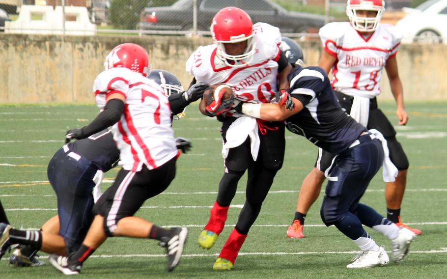 Nile C. Kinnick's' Dre Paylor tries to elude the tackle of Seoul American's Christian Guavera during Saturday's DODDS Pacific Far East Division I football game at Yongsan Garrison, South Korea. The Red Devils won 44-6.