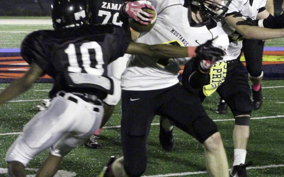 American School In Japan running back Ryan Murphy tries to slip past Zama American defender Jay Lavette during Friday's Kanto Plain Association of Secondary Schools football game at Naval Air Facility Atsugi, Japan. ASIJ won 35-6 and improved to 5-0 this season.