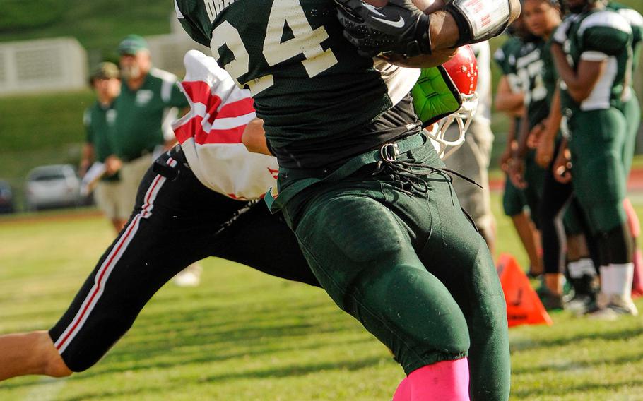 Kubasaki's Jarrett Mitchell gets shoved out of bounds by Nile C. Kinnick's Nick Galegher during Saturday's Division I football qualifier at Camp Foster, Okinawa. Mitchell rushed 15 times for 248 yards and three touchdowns, giving him 1,400 yards on 109 attempts this season, a new district record, as the Dragons won 38-7 and took over first place in the D-I standings.
