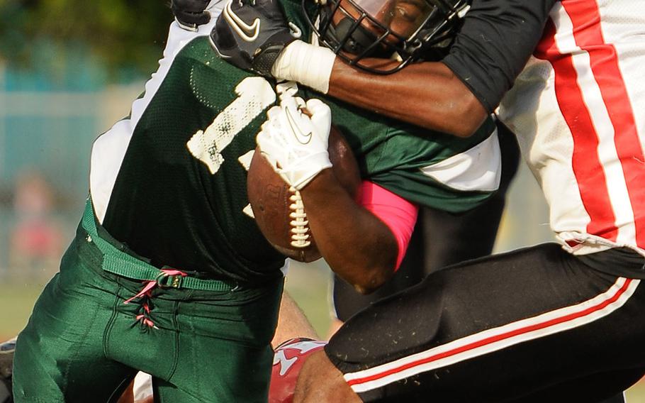 Kubasaki's Winston Maxwell gets tackled by Nile C. Kinnick's Marcel Daniels and Keigo Mull during Saturday's Division I football qualifier at Camp Foster, Okinawa. The Dragons won 38-7 and took over first place in the D-I standings.