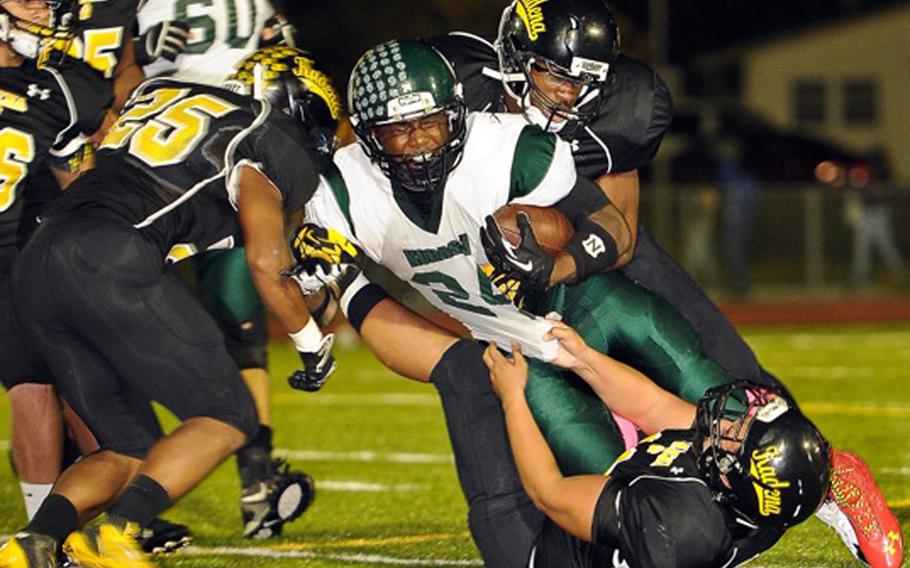 Kadena defenders D.J. Padilla, Preston Harris and Justin Sego collar Kubasaki  running back Jarrett Mitchell during Friday's football game at Kadena Air Base, Okinawa. Kadena won 11-0, capturing its first island season series since 2010.