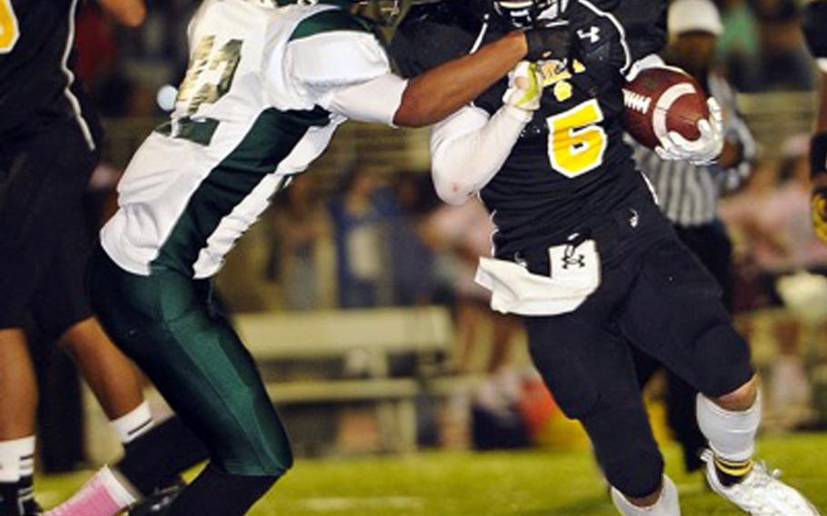 Kubasaki defender Jacob Green tries to tackle Kadena running back Justin Sego during Friday's football game at Kadena Air Base, Okinawa. Kadena won 11-0, capturing its first island season series since 2010.