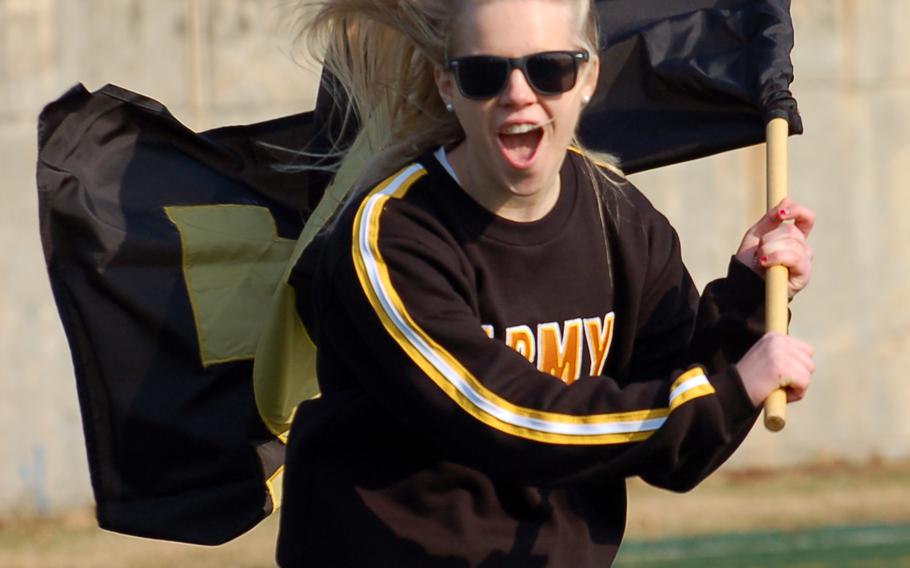 An Army cheerleader brandishes an Army team flag and shouts support for her players during Saturday's Korea Army-Navy flag football rivalry game at Yongsan Garrison, South Korea. The soldiers routed the sailors 62-0, improving to 14-3 in the Peninsula Trophy series.