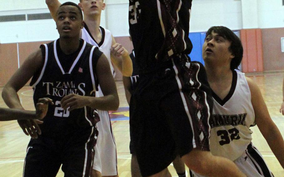 Zama American's Jason Chiarenza shoots between Matthew C. Perry defender R.J. Buldoc and Zama teammate Michael Patterson during Saturday's DODDS Japan high school boys basketball game at Naval Air Facility Atsugi, Japan. Zama won 50-20, sweeping the weekend series.