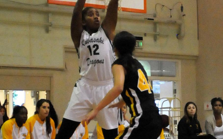 Kubasaki's Sydney Johnson passes over Kadena defender Linda Vaughan during Friday's Okinawa Athletics and Activities Council high school girls basketball game at Camp Foster, Okinawa. Kubasaki won 48-42, its first OAAC regular-season victory over Kadena in 10 years.