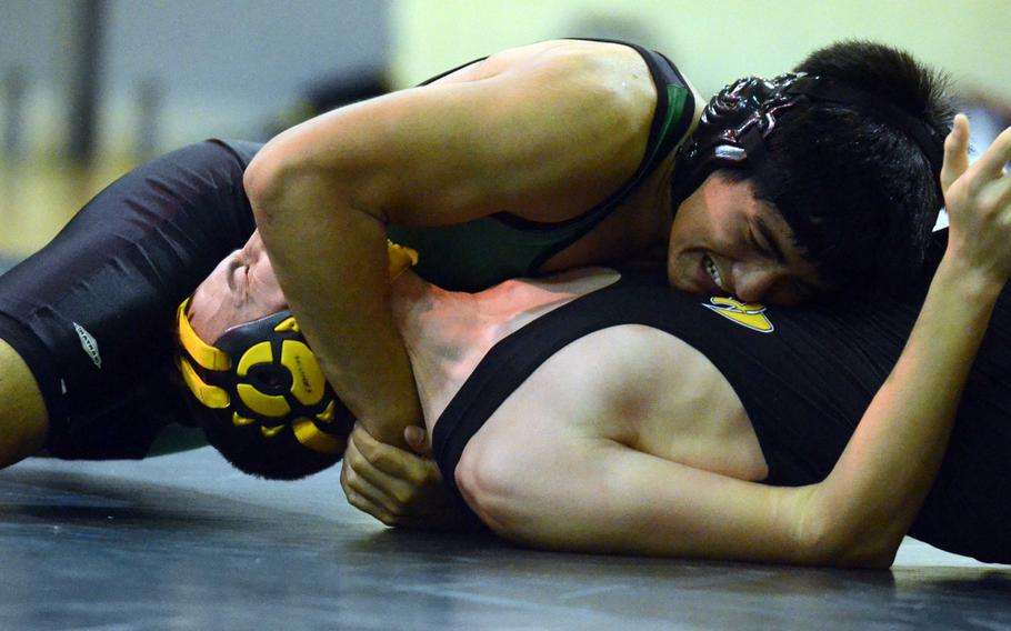 Kubasaki's Shoichiro Vivas puts the finishing touches on a grimacing Jacob Parker of Kadena in the 141-pound bout during Wednesday's Okinawa Athletics and Activities Council high school wrestling dual meet at Camp Foster, Okinawa. Vivas pinned Parker in 33 seconds.